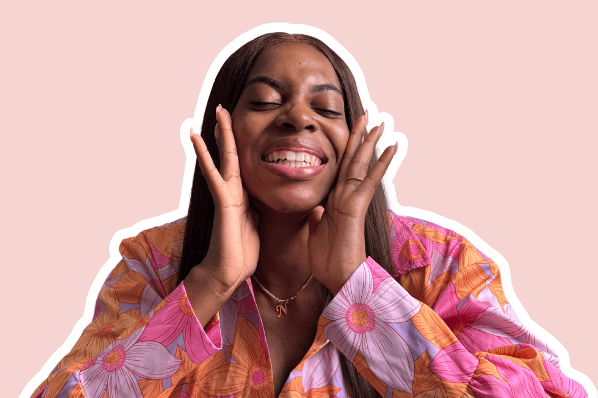 Nma Okafor with hands to mouth amd grinning widely.