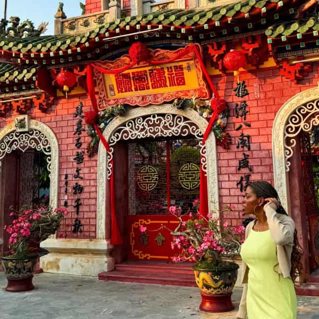 Bright Chinese temple entrance with vibrant red walls, intricate decor, and traditional symbols, showcasing cultural architecture and festive red lanterns at a colorful Asian heritage site.
